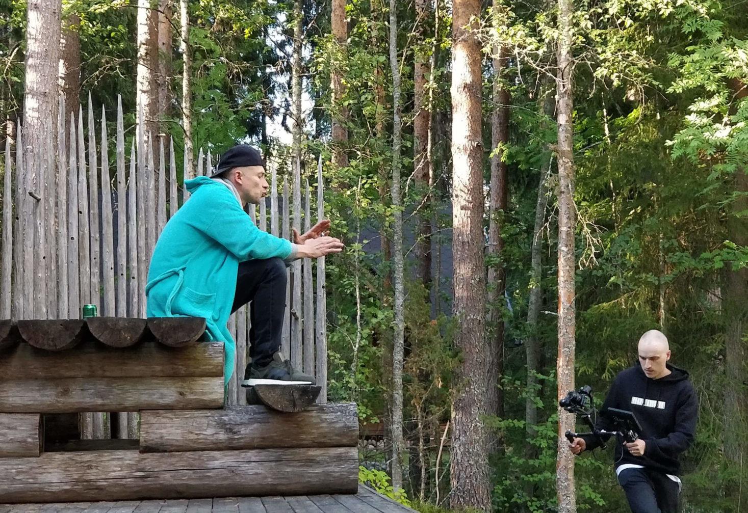 Asa räppää puuportailla metsän läheisyydessä videokuvaajan kuvatessa häntä.