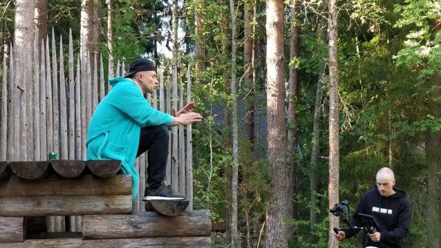 Asa räppää puuportailla metsän läheisyydessä videokuvaajan kuvatessa häntä.