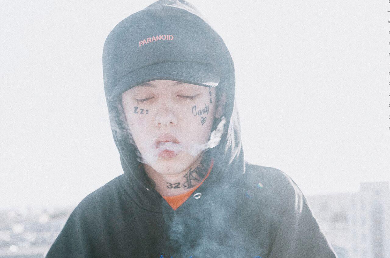 Lil Xan puhaltaa savua ulos suusta silmät kiinni.