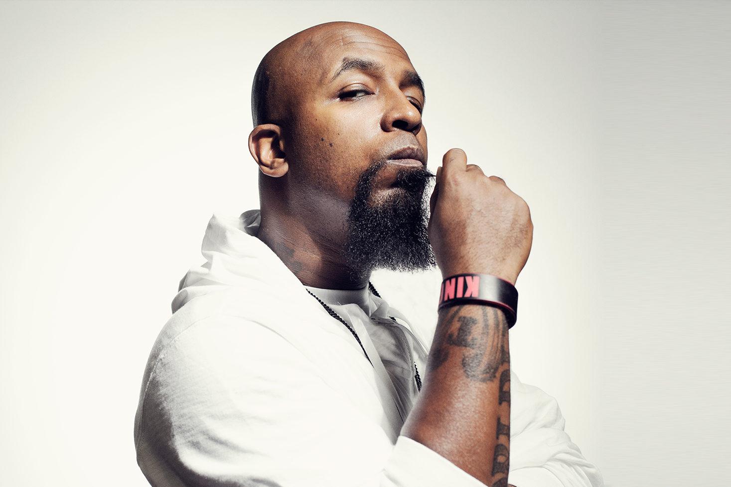 Tech N9ne poseeraa käsi leukaa vasten.