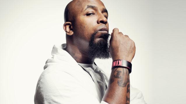 Tech N9ne poseeraa käsi leukaa vasten.