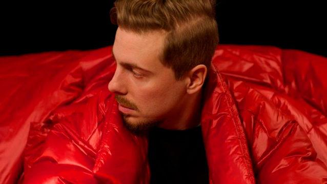 DJ Kridlokk katsoo punainen takki päällä sivusuuntaan.