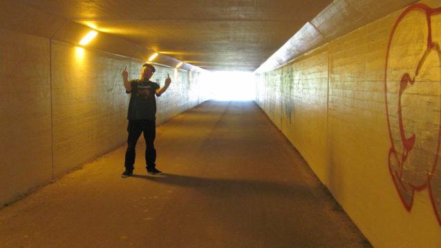 Dxxxa D näyttää käsimerkkejä alikulkutunnelissa.