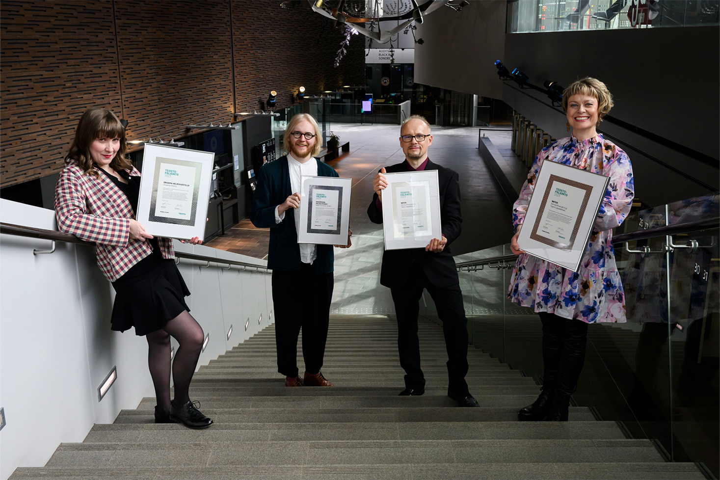 Draama-Helmi, Mikko Sarvanne, Tapio Lappalainen ja Sanna Ahvenjärvi poseeraavat palkintotaulujen kanssa portaikossa.