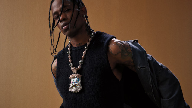 Yhdysvaltalaisräppäri Travis Scott riisumassa takkiaan.