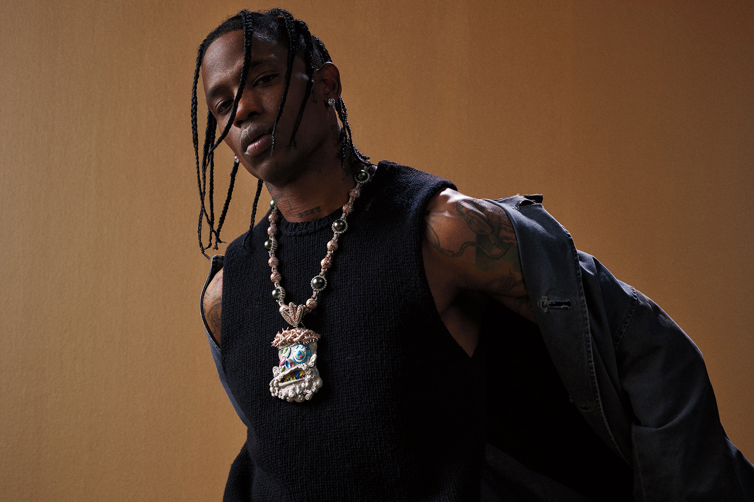 Yhdysvaltalaisräppäri Travis Scott riisumassa takkiaan.