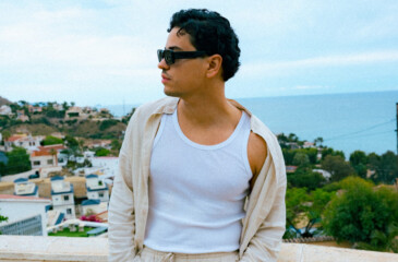 Karim B poseeraa parvekkeella marokkolainen kaupunkimaisema takanaan.