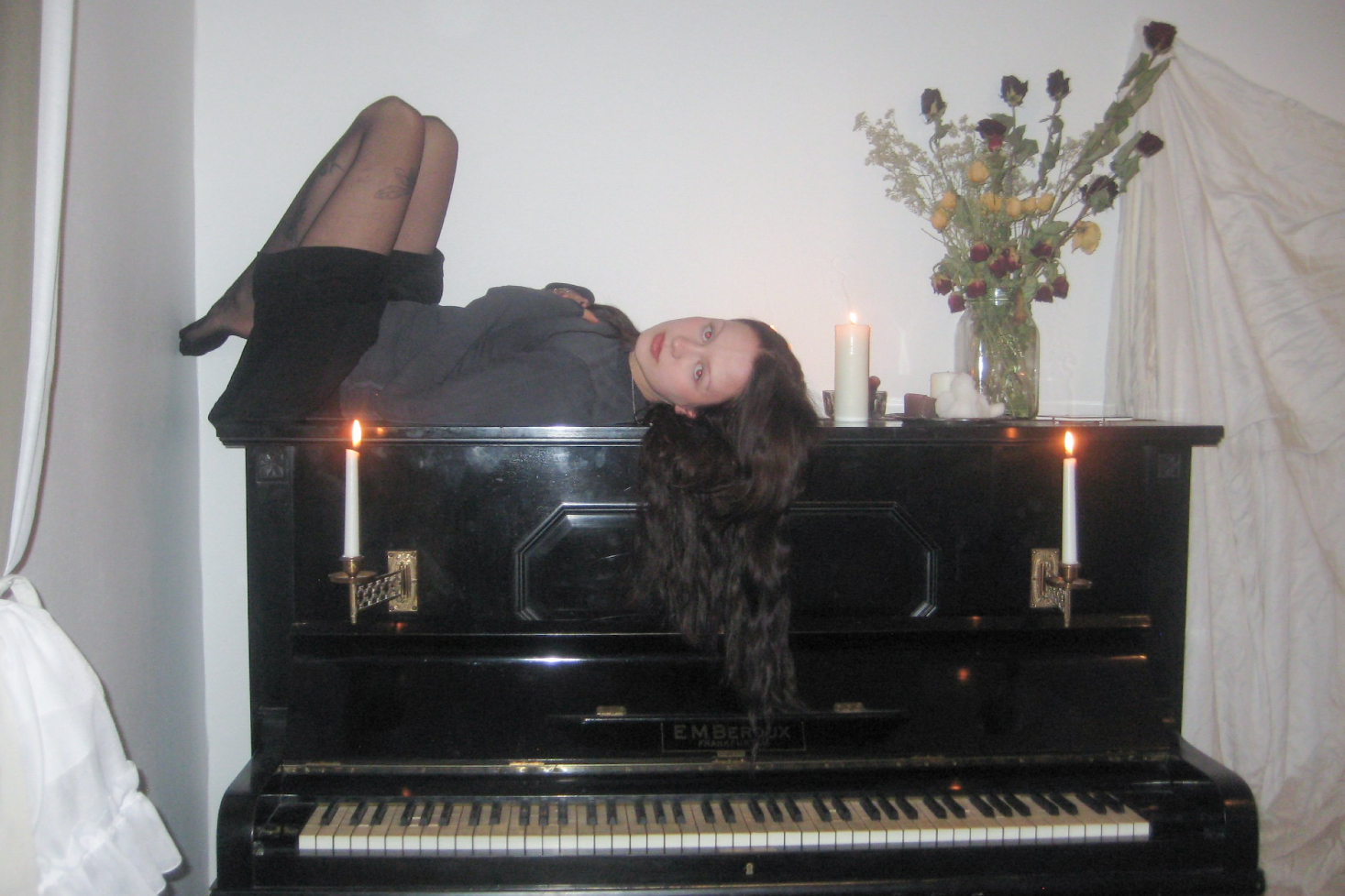 Pehmoaino makaa selälteen pianon päällä.