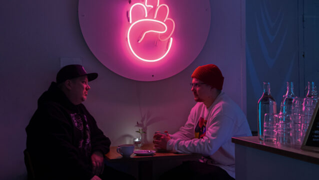 Anselmi ja Xmies istuvat kahdestaan pöydän äärellä.