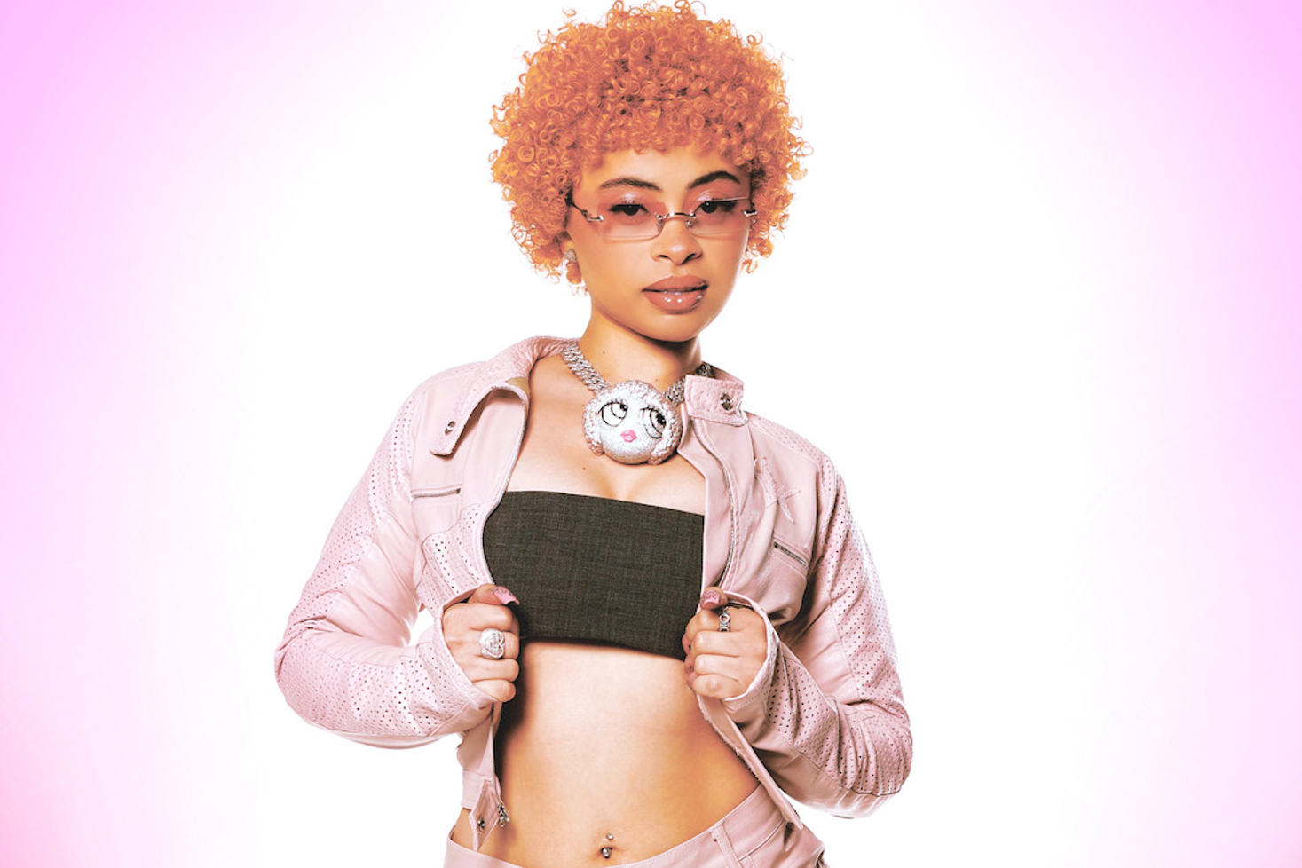 Ice Spice poseeraa musta toppi ja pinkki takki päällä.