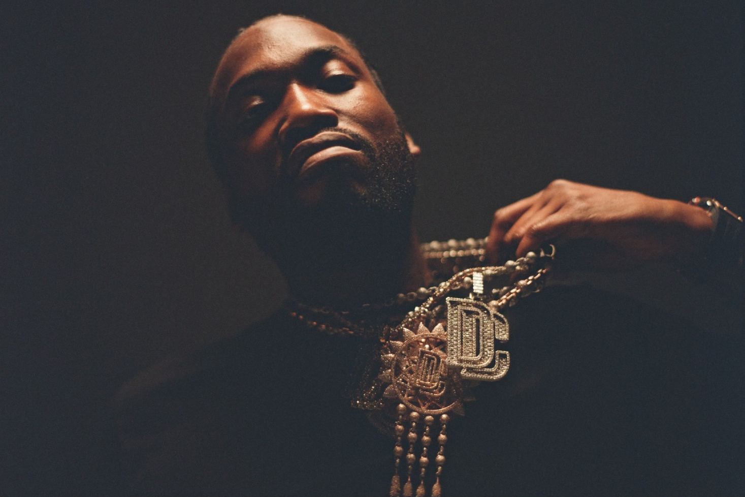 Meek Mill pitää kädellään kiinni kaulakorustaan.