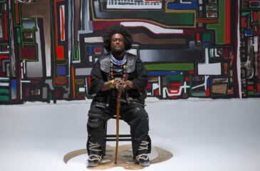 Kamasi Washington istuu tuolilla. Kamasi Washington palaa Suomeen!