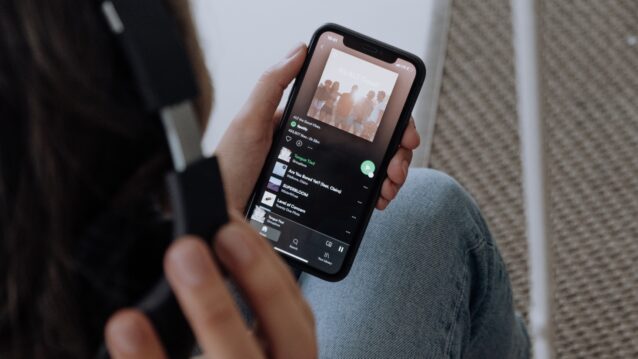 Joku pitää iPhonea. Miten tyhjentää Spotifyn välimuisti iPhonessa?
