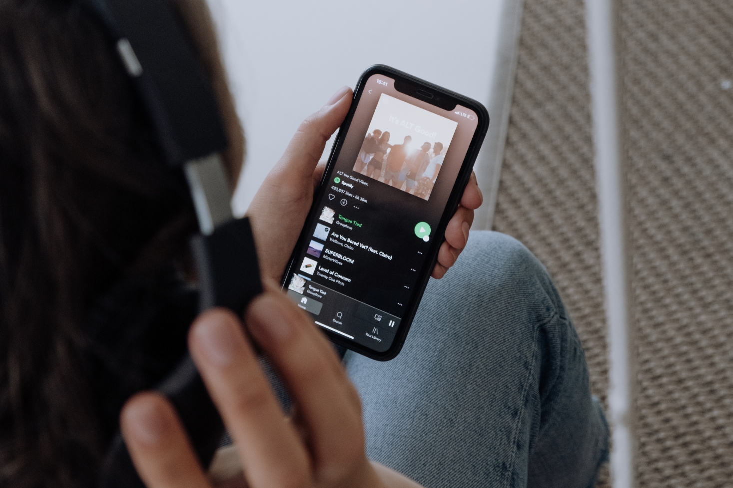 Joku pitää iPhonea. Miten tyhjentää Spotifyn välimuisti iPhonessa?