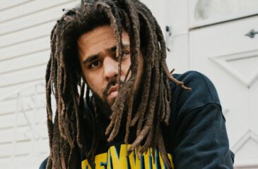 J.Cole kuvattuna istumassa valkoisen seinän edessä. Cam'ron haastoi J. Colen oikeuteen Ready ‘24 -kappaleesta!