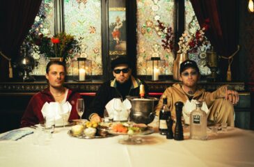 Mouhouksen jäsenet istuvat pöydässä Ladabois-promokuvassa