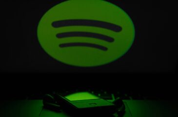 Spotify-logo puhelimen yläpuolella. Spotify Wrapped 2025 lähestyy!