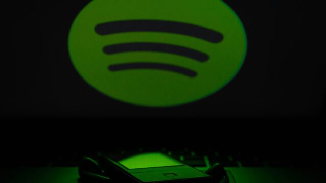 Spotify-logo puhelimen yläpuolella. Spotify Wrapped 2025 lähestyy!