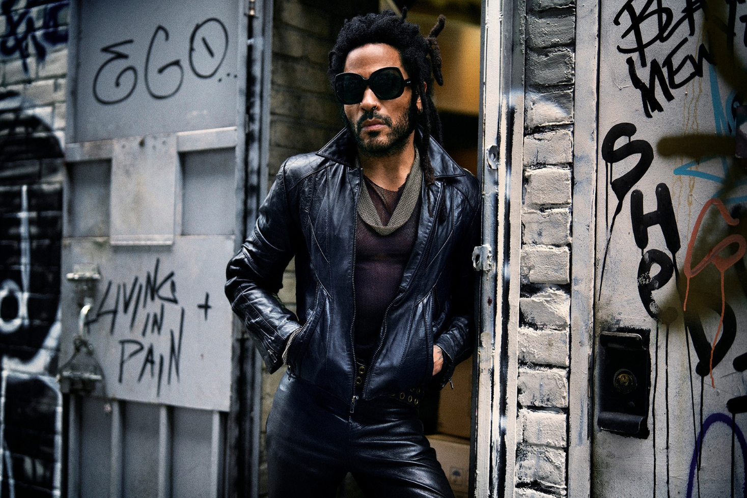 Lenny Kravitz nojaa seinää vasten. Rock-legenda Lenny Kravitz palaa Suomeen!
