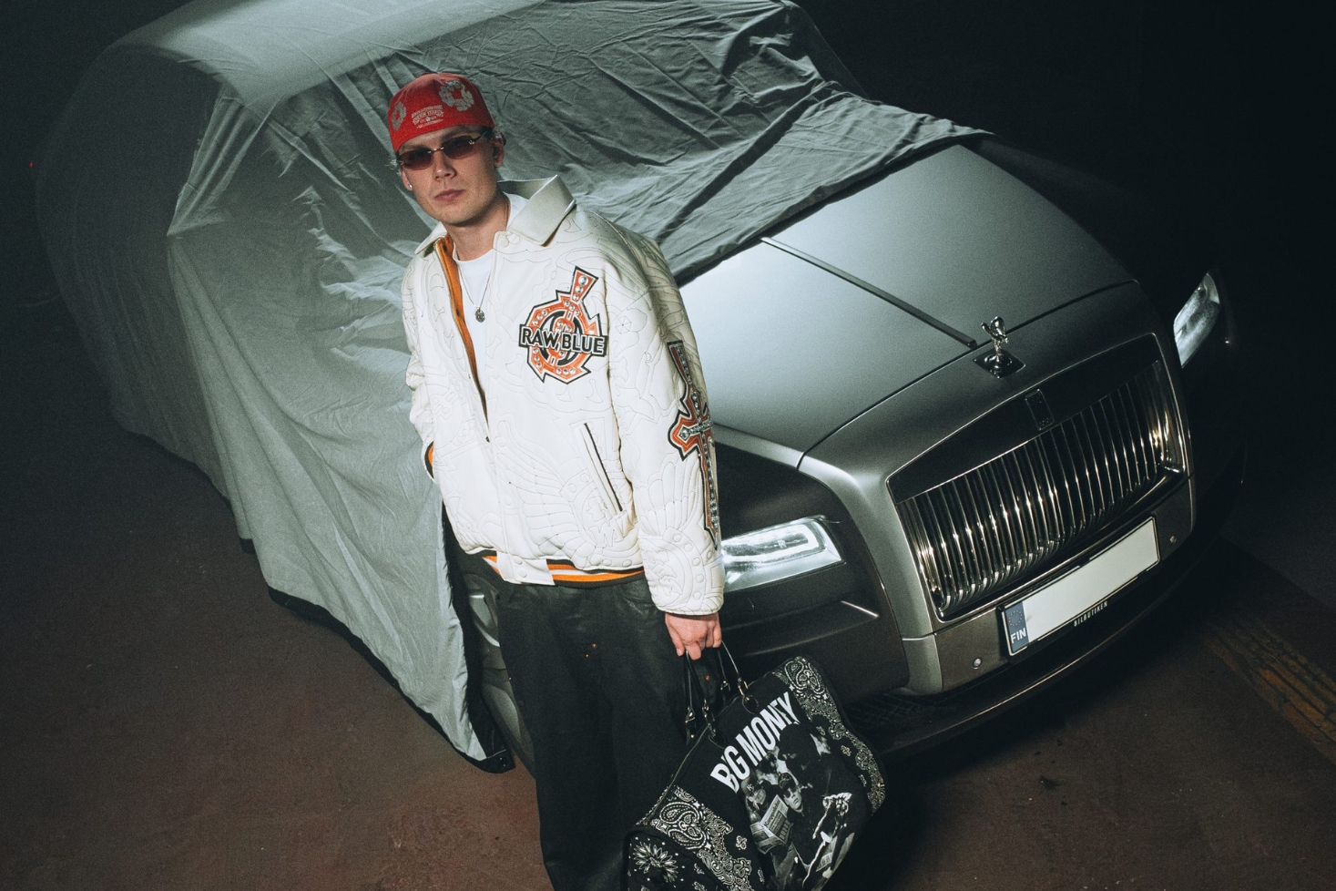 Sliki auton edessä laukku kädessä. Sliki palaa tauolta!