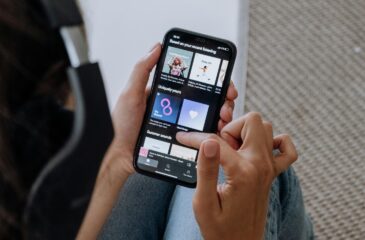 Henkilö selaa Spotify-suosituksia sovelluksesta puhelimella. Suomen Spotify-soittolistojen kuratointi siirtyy Ruotsiin