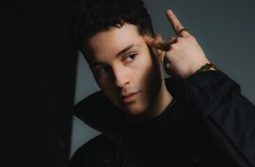 Ares näyttää A-käsimerkkiä Aris-promokuvassa