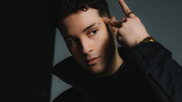 Ares näyttää A-käsimerkkiä Aris-promokuvassa