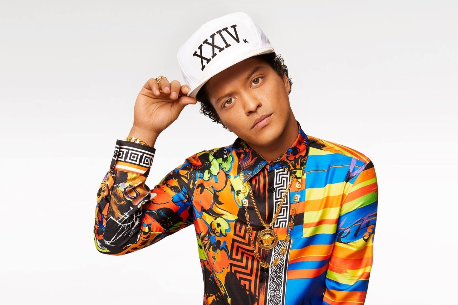 Bruno Mars valkoinen lippis ja värikäs kauluspaita päällä