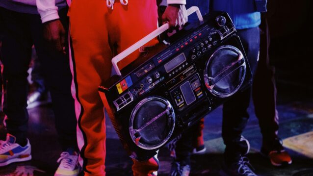 Henkilö pitää vanhanaikaisesta radiosta kädellä kiinni. Kun suomirapista tuli valtavirtaa, jotain olennaista katosi!