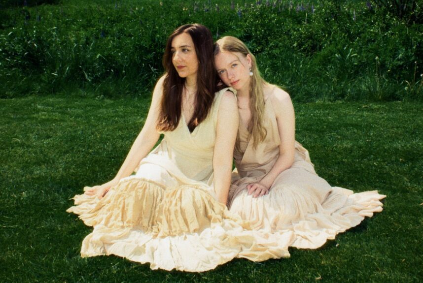 Emma & Matilda nurmikolla istumassa. Emma & Matilda esiintyvät Yle Kesäfestivaali 2026 -tapahtumassa!