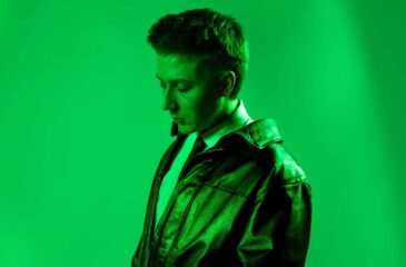 sane HITMAN-albuminsa promokuvassa vihreää taustaa vasten