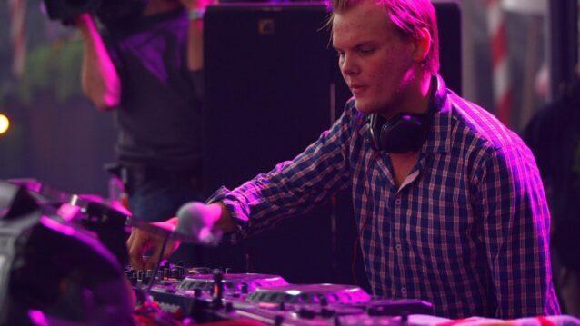 Avicii miksauspöydän ääressä ruutupaidassa ja kuulokkeet kaulassa Tomorrowlandin päälavalla vuonna 2011