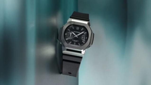 G-Shock GMC-2500, analoginen kello, jossa on hopeanvärinen kotelo, musta kellotaulu ja musta ranneke