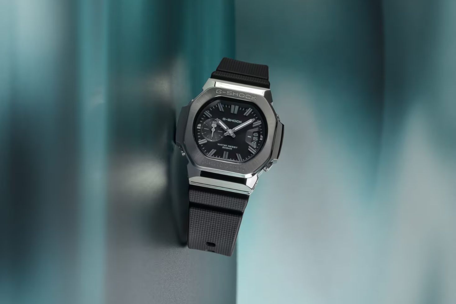 G-Shock GMC-2500, analoginen kello, jossa on hopeanvärinen kotelo, musta kellotaulu ja musta ranneke
