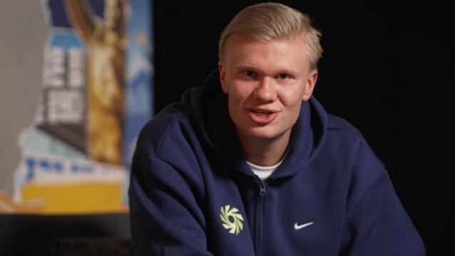 Erling Haaland, Call of Duty -camper, puhuu kameralle tummansinisessä hupparissa.