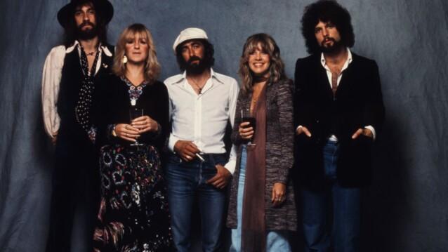 Fleetwood Mac -dokumentti: yhtyeen viisi jäsentä poseeraa harmaata kangastaustaa vasten 1970-luvun tyyliin pukeutuneina
