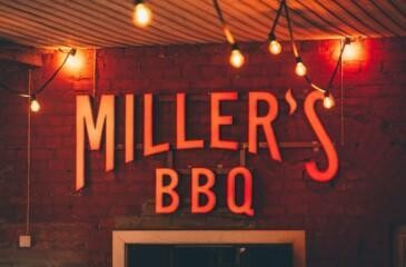 Miller’s BBQ Töölö -ravintolan valokyltti tiiliseinällä