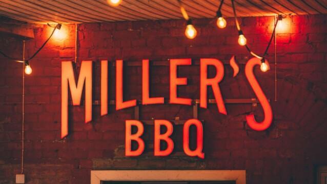 Miller’s BBQ Töölö -ravintolan valokyltti tiiliseinällä