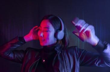 Tekijänoikeusbarometri 2026 – nainen kuuntelee musiikkia kuulokkeilla neonvalossa