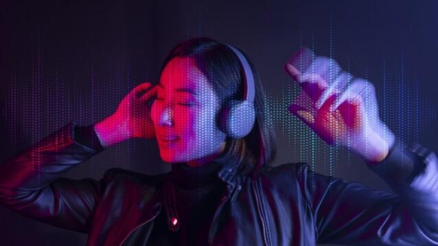 Tekijänoikeusbarometri 2026 – nainen kuuntelee musiikkia kuulokkeilla neonvalossa